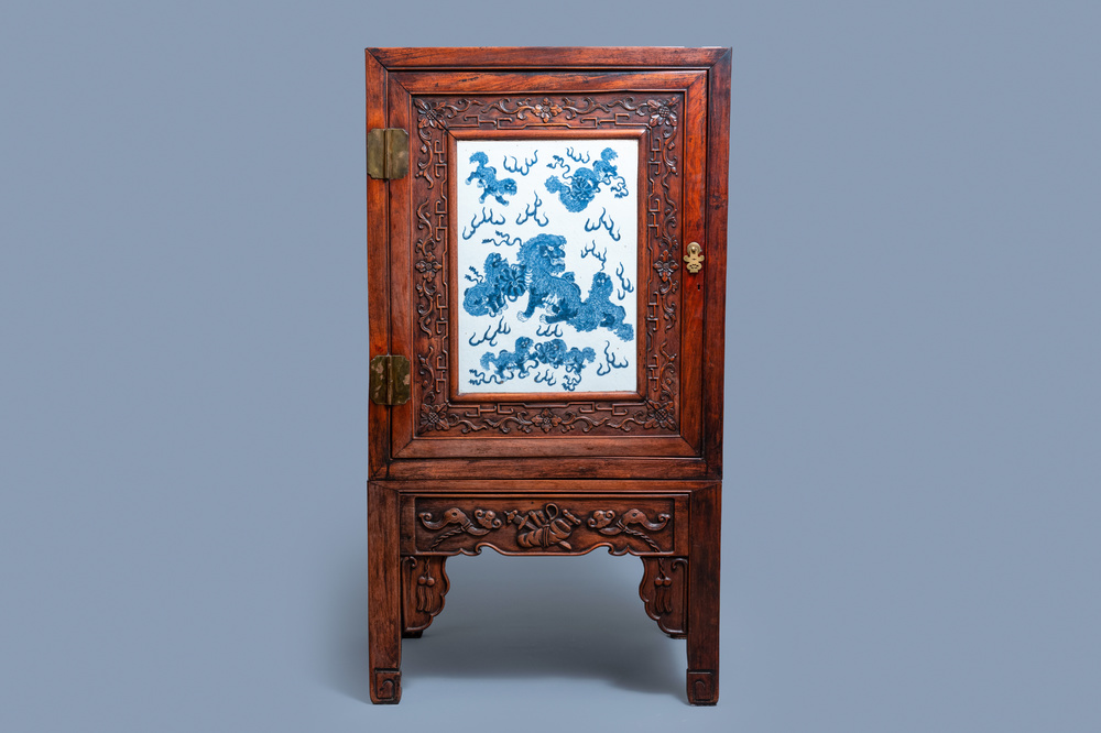 A Chinese hongmu cupboard with a blue and white 'Buddhist lions' plaque, 19th C.